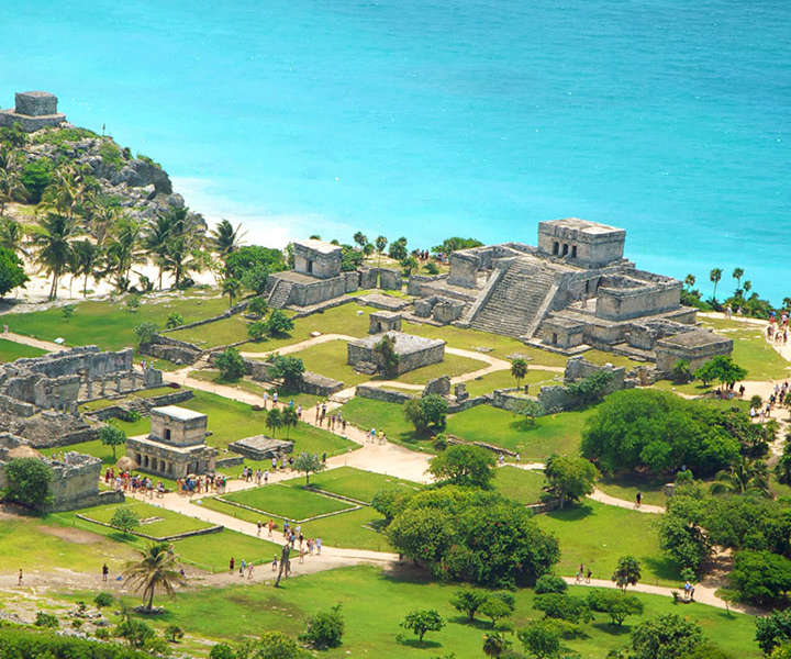 El emblemático Castillo de la zona arqueológica de Tulum edificado sobre el acantilado frente a las aguas turquesas del Mar Caribe durante un tour con Vaguemos Viajes